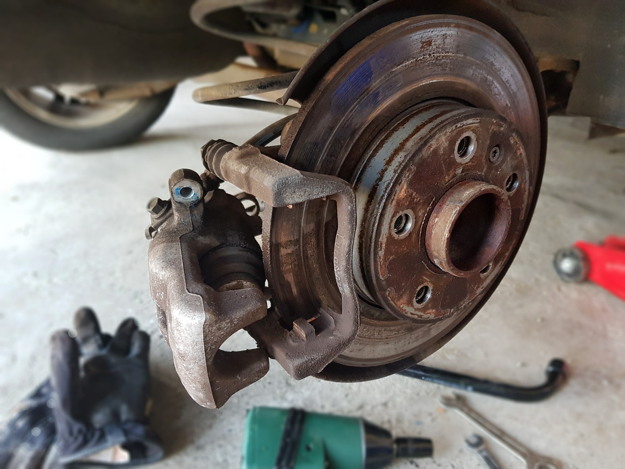 Close-up image of brand brake disc and brake caliper installed on car.